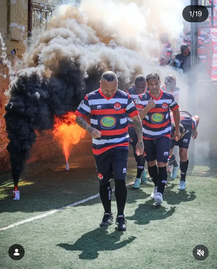 Jogadores entrando em campo com fumaça e energia